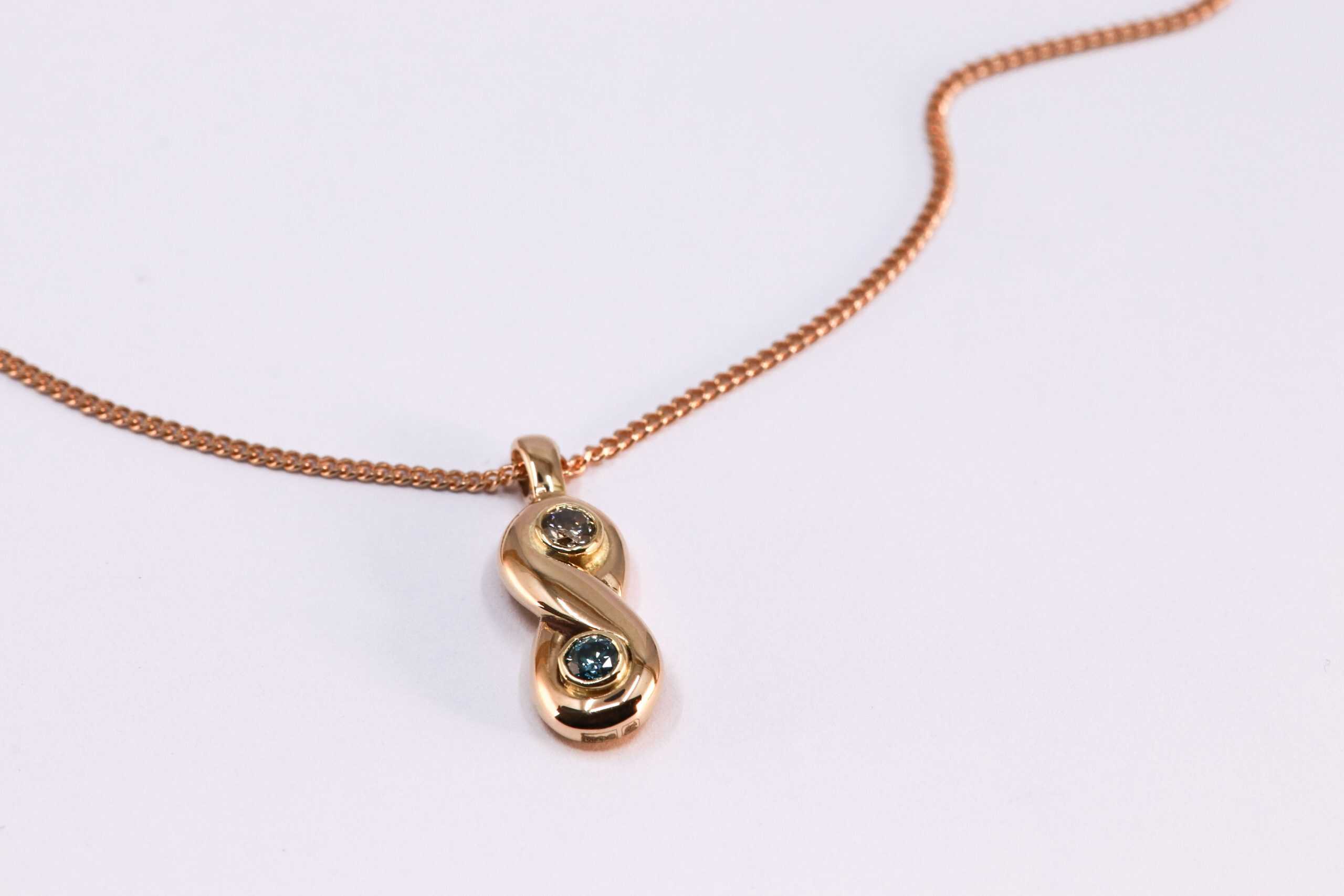 18K geelgouden geboortehanger INFINITY met 2 fancy kleur diamanten, vervaardigd door Burgant.