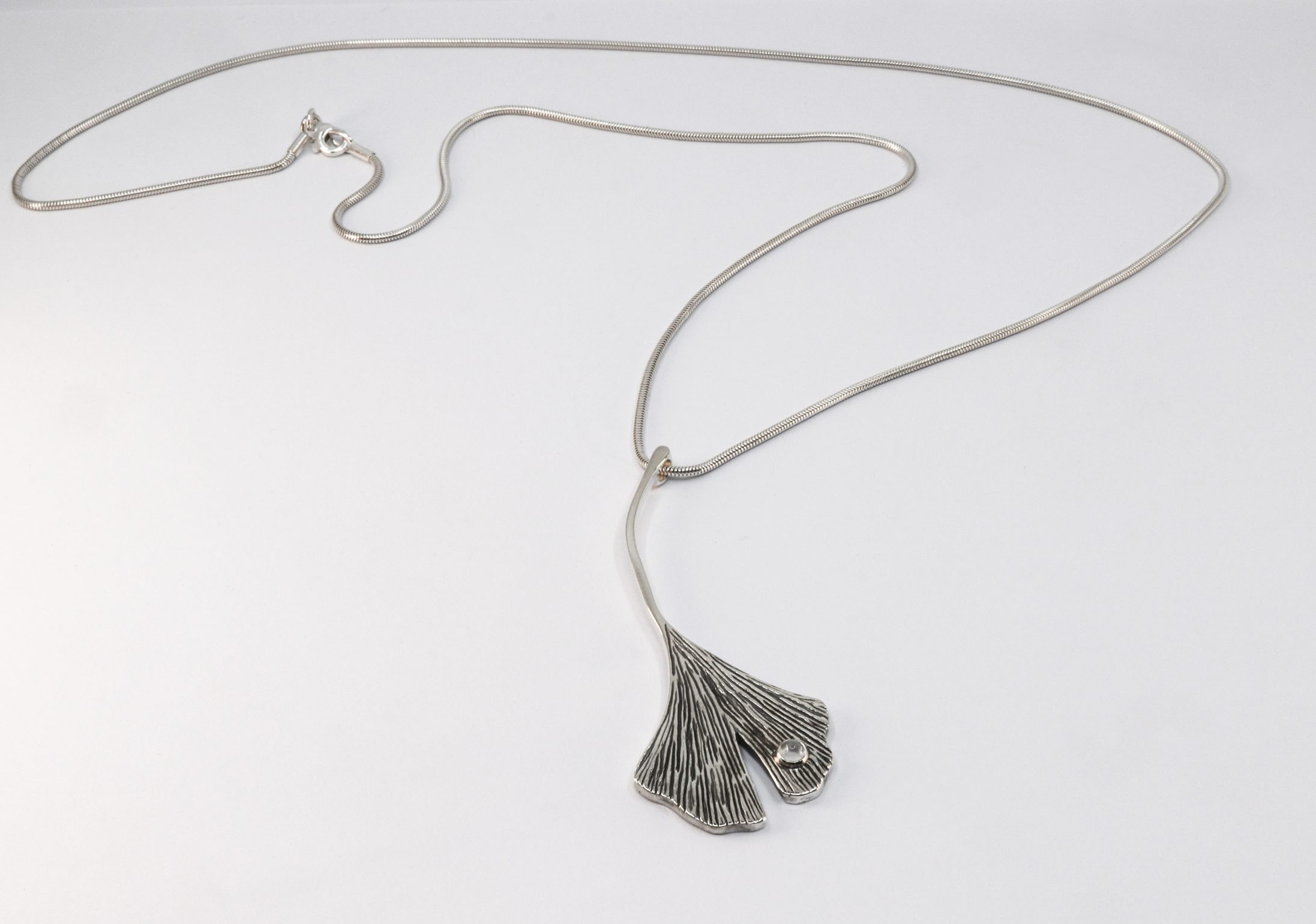 Zilveren ashanger Ginkgo Biloba met gouden details en bergkristal collier. Gemaakt door Burgant.