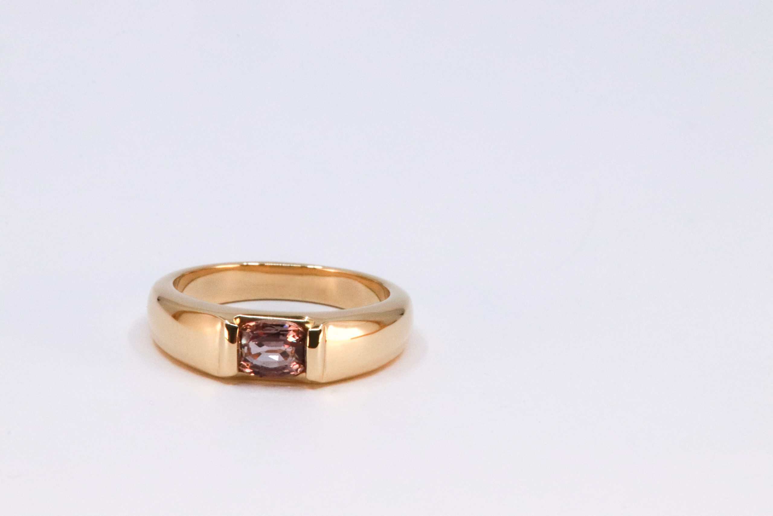 Gouden ring met roze paarse saffier, vervaardigd van een dierbare trouwring