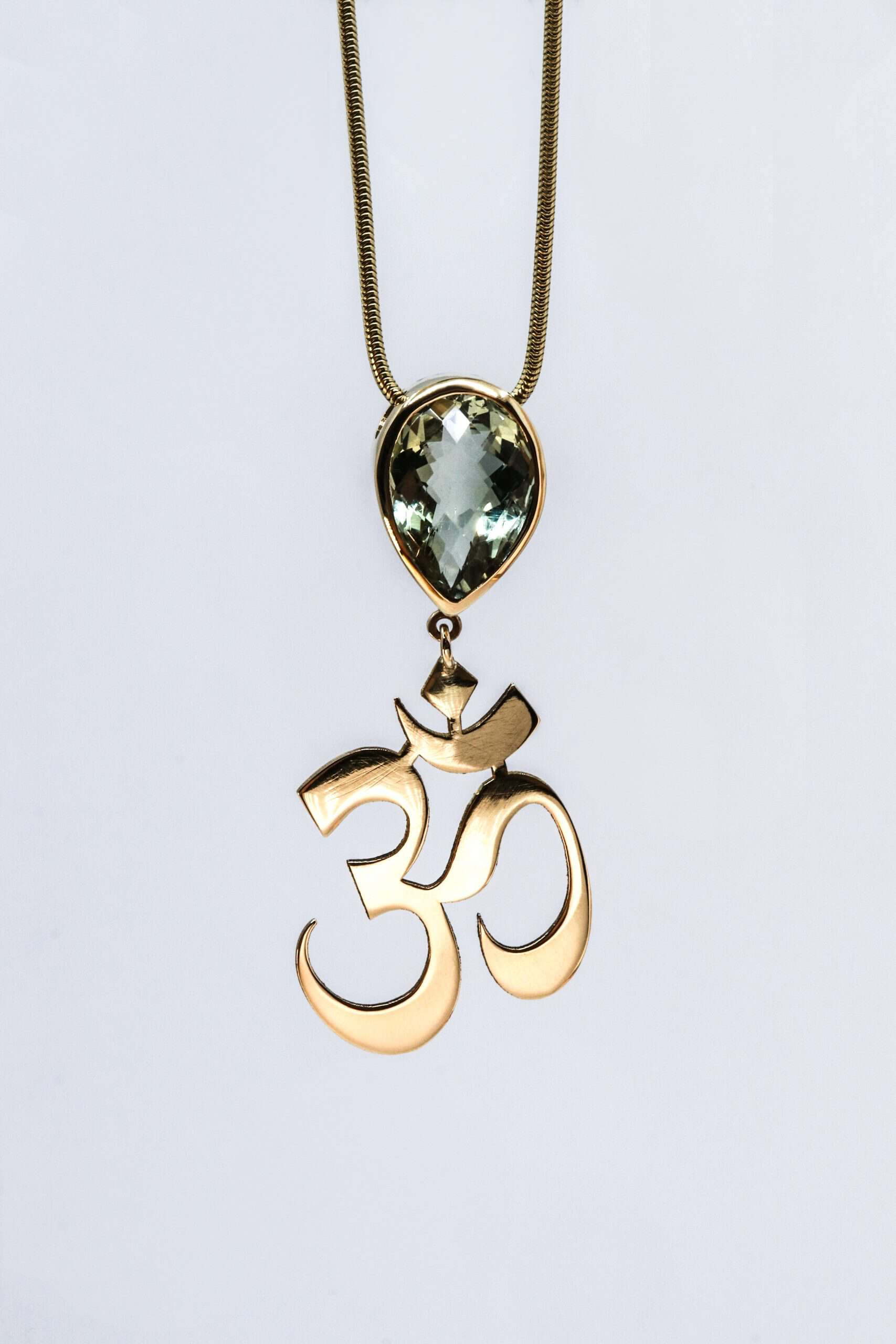 HerinnerHanger AUM met aquamarijn en collier, vervaardigd door Burgant van oud dierbaar goud als persoonlijk herinneringssieraad.