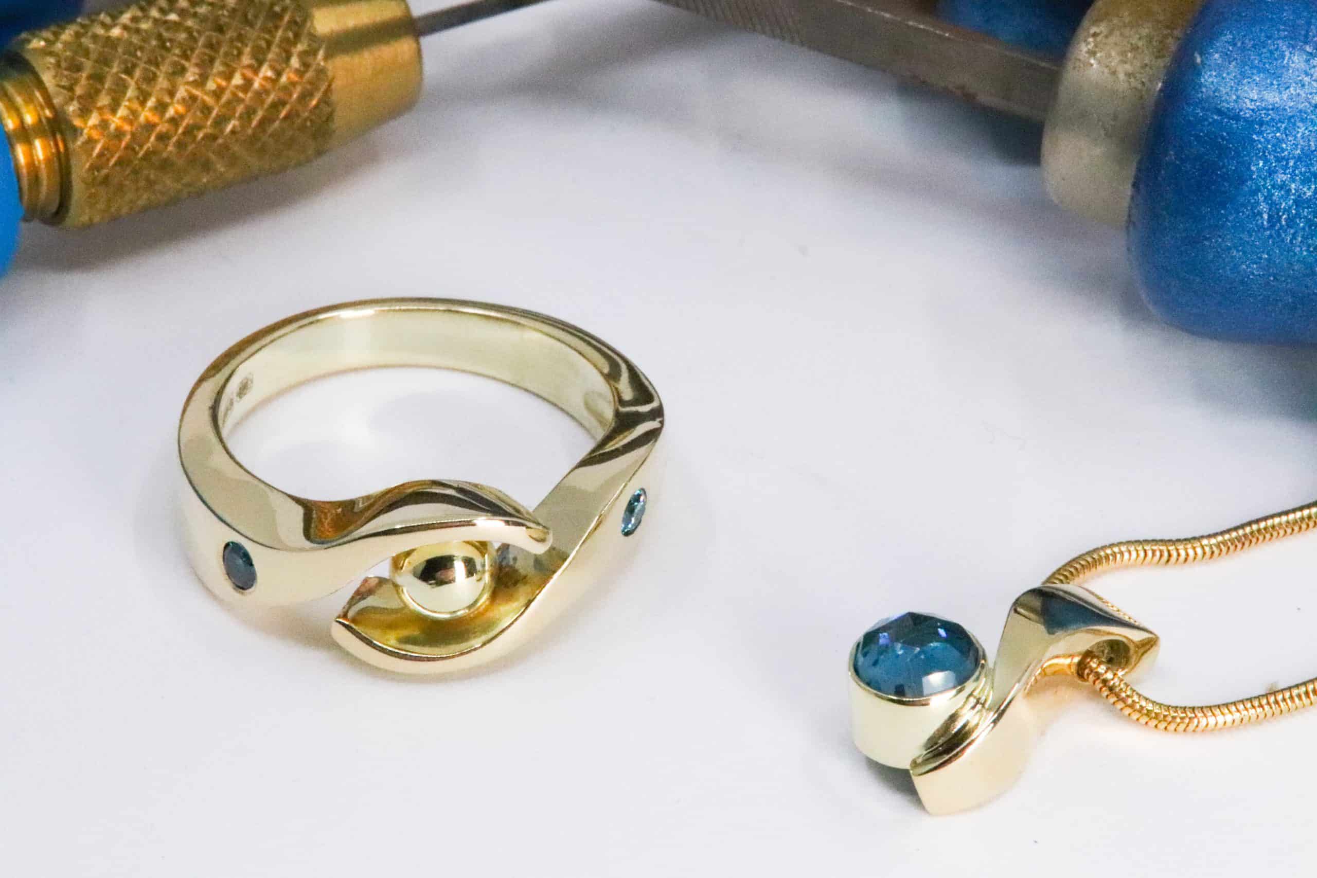 Set van 14K gouden damesring met twee sky diamanten en 14K gouden hanger met London Blue topaas, vervaardigd door Burgant als uniek maatwerk sieraad.