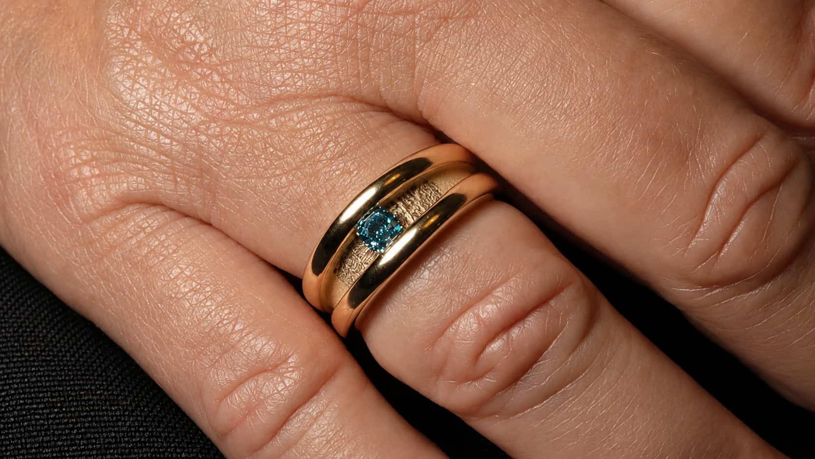 Herdenkingsring van dierbaar oud goud met vingerafdruk van vader en blauwe diamant, op maat gemaakt in het atelier van Burgant.